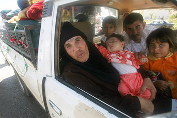 A Lebanese Bedouin woman and her family rejoice as they prepare to cross the Syrian-Lebanese border just hours after a ceasefire came into force on August 14th, 2006.
